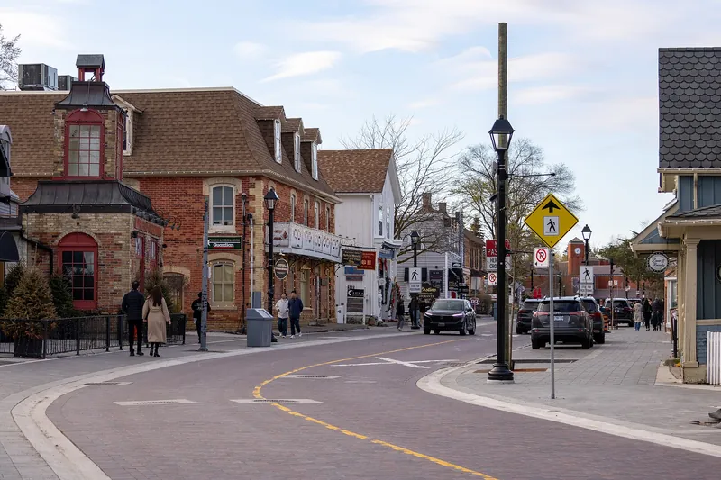 Main Street Unionville looking north — heritage brick and clapboard shopfronts, with the white 182 building on the left